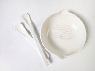 White Set of children's bowl and spoons on the white background. Baby tableware. Nutrition and first level Baby's feeding concept