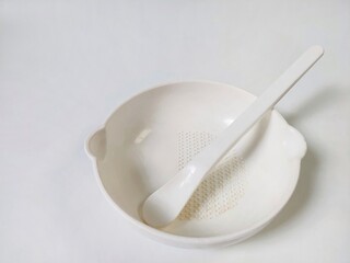 White Set of children's bowl and spoon on the white background. Baby tableware. Nutrition and first level Baby's feeding concept