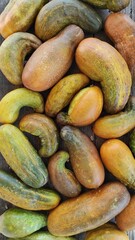 Overripe Cucumbers Displayed on a Rustic Wooden Surface Illustrate Farmers' Harvests in Late Summer