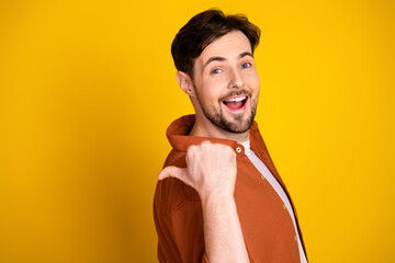 Happy young man in casual outfit pointing to himself against yellow background with cheerful expression