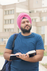 Vertical Photo of Sikh Indian Student Thinking with Notebook in Hand