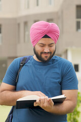 Vertical Photo of Happy Sikh Indian Student Reading Book