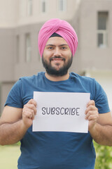 Vertical Photo of Sikh Indian Man Holding Subscribe Poster