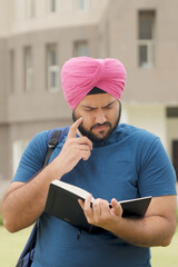 Vertical Photo of Confused Sikh Indian Student Reading Book