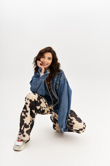 Stylish woman poses confidently in trendy cow print pants on a grey backdrop
