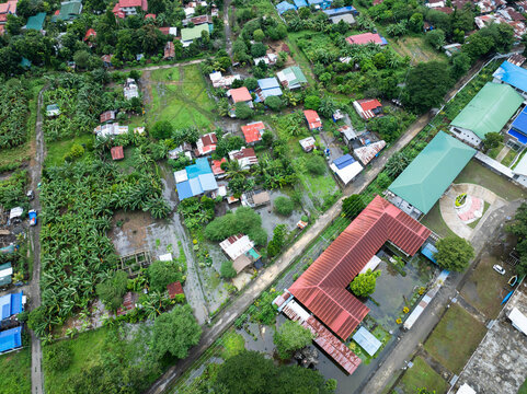 Aerial view of the flooded landscape, where homes and buildings stand amidst the water, reflecting the sky above, Tiwi, Western Visayas, Philippines.