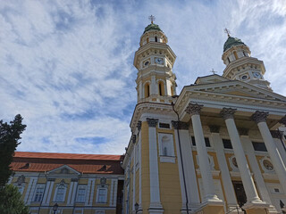 Church with yellow facade and golden domes against clear blue sky