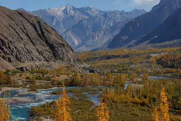 Fototapeta premium Autumn view Flowing blue water of Gilgit River with Hindu Kush mountain range in the background,Gahkuch, Pakistan.