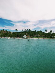 Aerial view from Praia dos Carneiros, Pernambuco: turquoise sea, white sandy beach, endless palm trees and a charming seaside chapel create the perfect tropical paradise in northeast Brazil