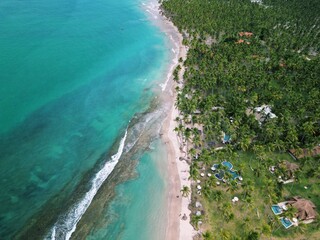 Aerial view from Praia dos Carneiros, Pernambuco: turquoise sea, white sandy beach, endless palm trees and a charming seaside chapel create the perfect tropical paradise in northeast Brazil