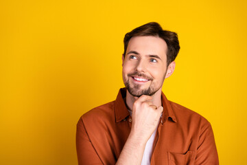 Casual young man with a charming smile and thought-provoking facial expression against a vibrant...