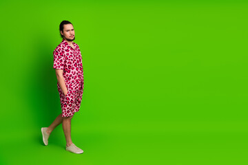 Trendy and stylish young man in a vibrant pink leopard shirt poses confidently against a bright...