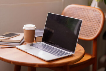 Fototapeta premium Remote work laptop home office setup with coffee and books for productive online learning or digital nomad lifestyle in a modern cozy workspace