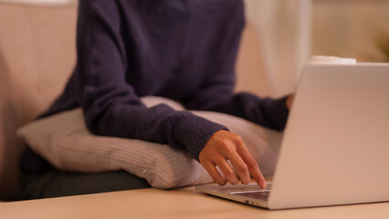 Asian adult hands typing on laptop computer managing online work digital business tasks productive remote lifestyle home comfortable setting