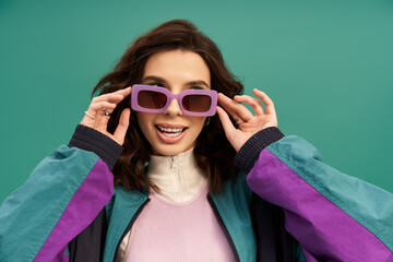 Stylish young woman showcasing sporty fashion against a vibrant turquoise backdrop