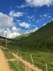 Mountain Trail through Lush Green Valley under Blue Sky