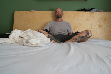 Man sitting on the bed meditating