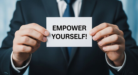 Obraz premium Man in Suit Holding Empower Yourself Sign White Card