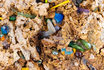 Colorful gemstones embedded in textured natural rock at a geological site during daylight