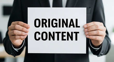 Obraz premium Person in Black Suit Holding Original Content Sign