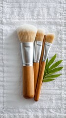 Wooden Makeup Brushes on White Towel with Green Leaf