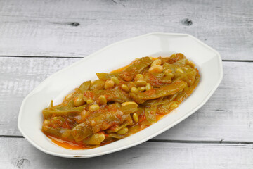Homemade stewed green beans, tomatoes, garlic with olive oil. Zeytinyagli fasulye traditional food. Turkish cuisine.