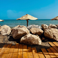 Parasol behind large boulders at the beach under a blue sky. Andalucia, Spain.