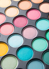 A close up view of a colorful makeup palette filled with various eyeshadow shades