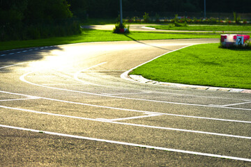 Racing Track Curve with Green Grass and Sunlight Reflection