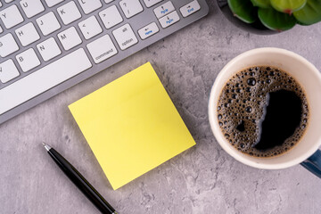 Top view of Blank sticky adhesive note with a cup of coffee
