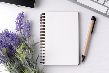 Top view of blank notepad with lavender flower and pen