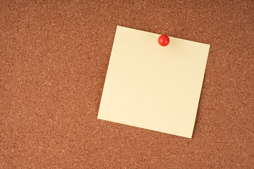 Blank sticky note on a cork board