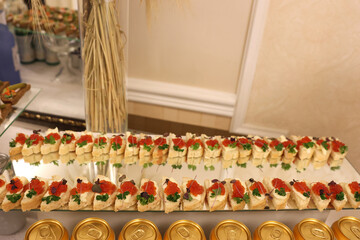 Beautiful, delicious buffet table with canapes, sausages, ham, cheese