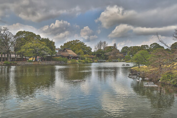 March 24 2025 Serene Lakeside Scene with Reflections and Lush Garden, Japan