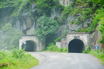 Two tunnels are on a road with a sign that says no entry