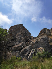 Large rock formation with a bird flying in the sky