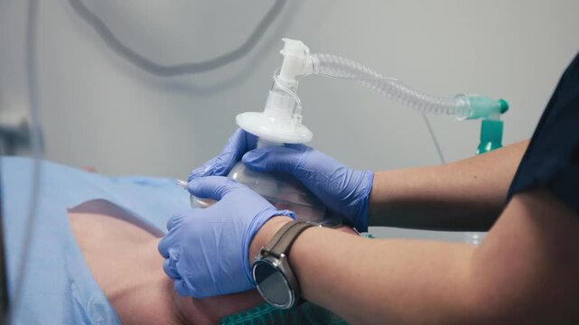 Patient receiving medical treatment with an airway management device, lying on a hospital bed, showcasing healthcare technology and patient care in a clinical environment