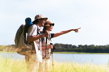 Man and woman are enjoy seeing a beautiful landscape and lake view.