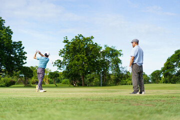 Asian man and elderly father are enjoy playing golf together with a good time.