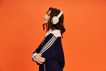 Stylish young woman in trendy jacket and skirt poses creatively in vibrant studio