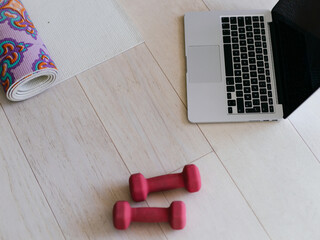 Photo of a laptop, dumbbells and headphones on the floor of the living room. Online training concept. High quality photo