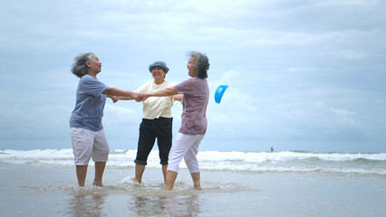 Happy senior women enjoying a playful walk on the beach