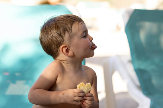 ni&ntilde;o merendando en una hamaca de piscina haciendo una burla con la lengua.