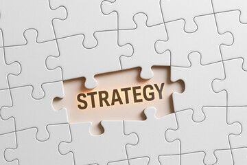 Fototapeta premium Strategy Puzzle Unveiled: A close-up view of a puzzle with STRATEGY prominently displayed, symbolizing problem-solving, innovation, and the critical nature of a well-defined plan
