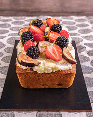 Rectangular Cake with Cream and Fresh Fruits on Rustic Background