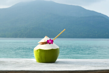 Young coconut juice on beach view with blue sea and blue sky background.