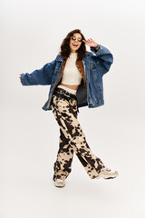Stylish young woman showcases trendy cow print pants in modern studio setting