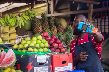 african market man selling fruits items counting money