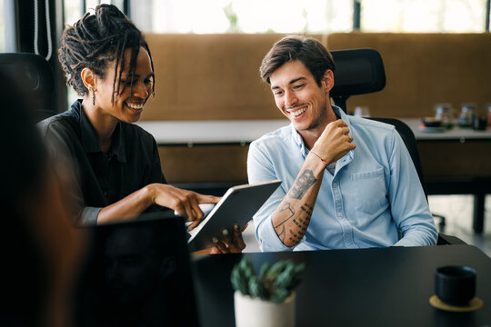 Group of young multi-ethnic startup business team collaborating on project in modern office