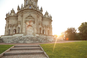 Beautiful entrance with old stone stairs to door in baroque medieval style old church building on nature bright sun light, vintage stone stairs. Europe religion architecture building in sunset rays